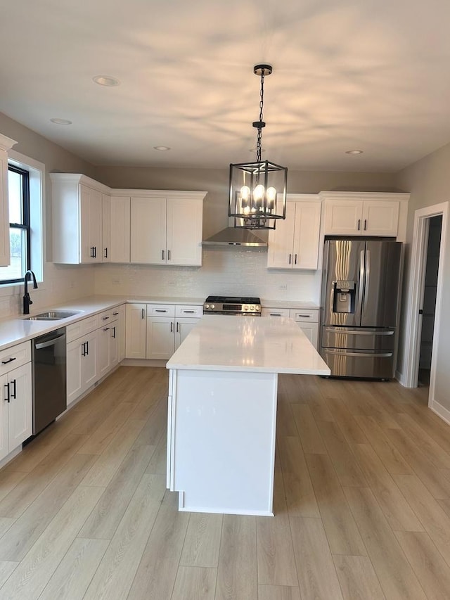kitchen featuring a sink, stainless steel appliances, light countertops, decorative backsplash, and a chandelier