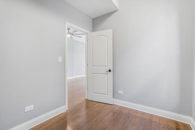 empty room featuring baseboards, ceiling fan, and wood finished floors