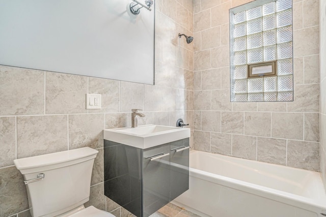 full bath with tile walls, vanity, toilet, and bathing tub / shower combination