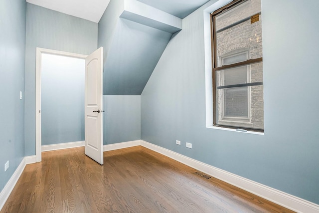 bonus room with visible vents, baseboards, and wood finished floors