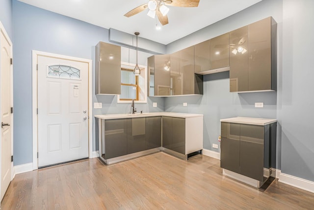 kitchen with modern cabinets, light wood-style flooring, gray cabinetry, a sink, and ceiling fan