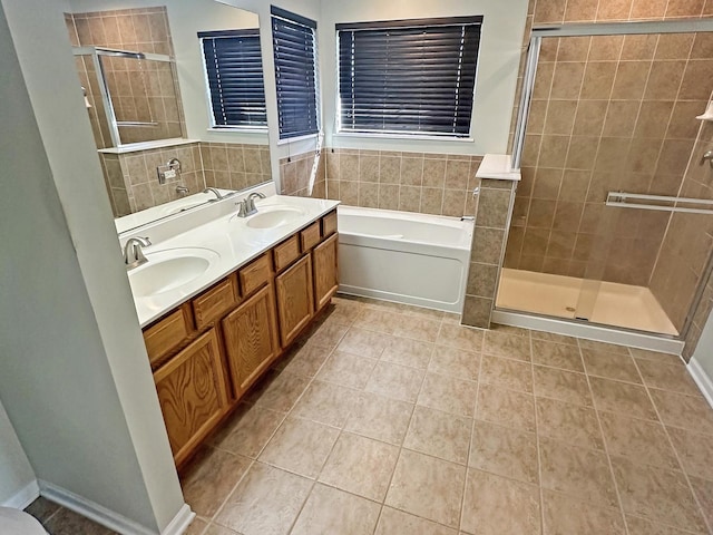 full bathroom featuring tile patterned floors, a shower stall, a garden tub, and a sink