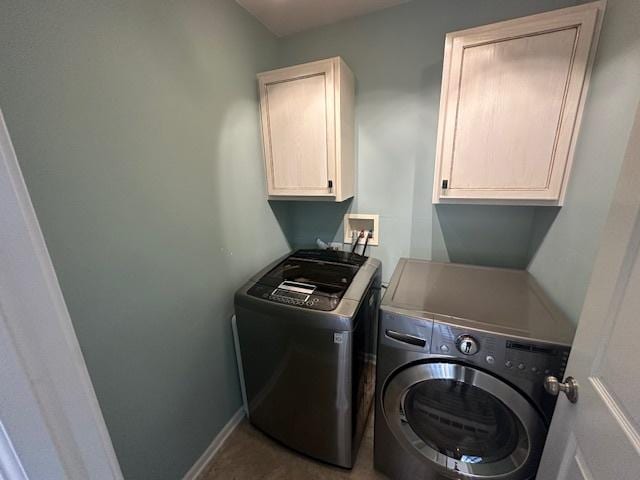 clothes washing area with cabinet space, independent washer and dryer, and baseboards