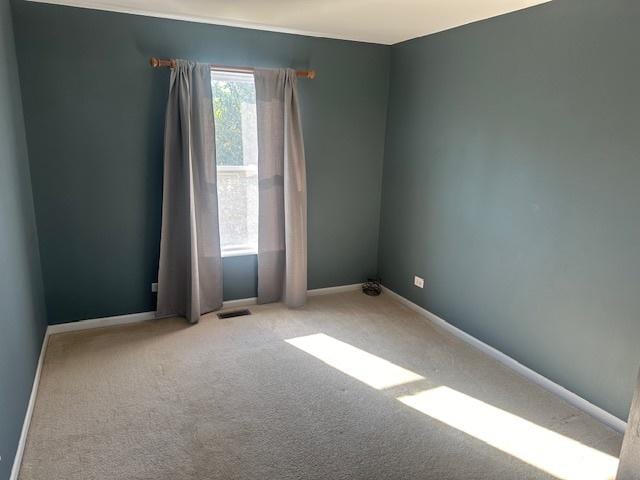 empty room with visible vents, baseboards, and carpet floors