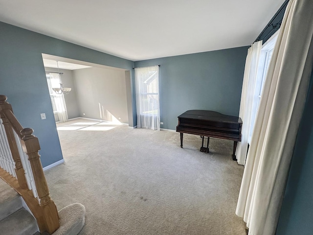 sitting room featuring a notable chandelier, carpet flooring, plenty of natural light, and baseboards