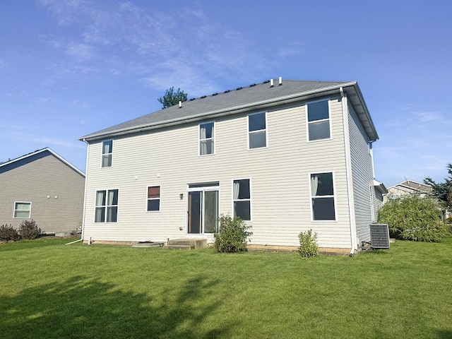 back of house featuring cooling unit and a lawn