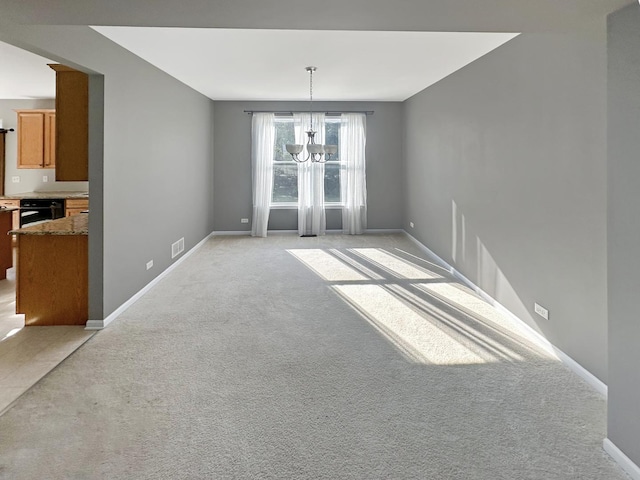 unfurnished dining area with baseboards, light carpet, an inviting chandelier, and visible vents