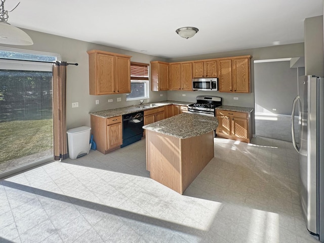 kitchen with a sink, a kitchen island, stainless steel appliances, light stone countertops, and light floors