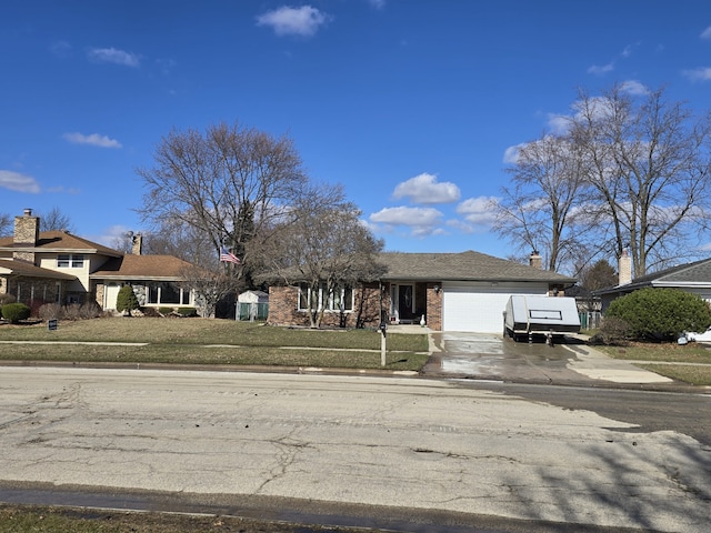 view of front facade with brick siding, concrete driveway, a front lawn, and an attached garage