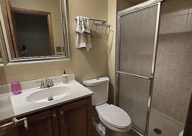 full bathroom featuring toilet, vanity, and a stall shower