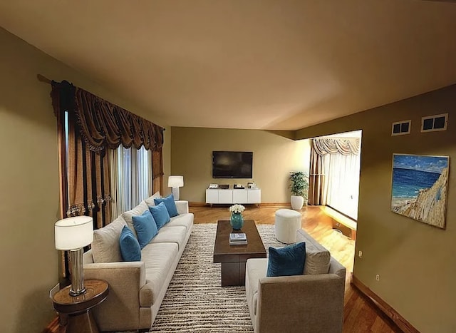 living room with baseboards, a wealth of natural light, and wood finished floors