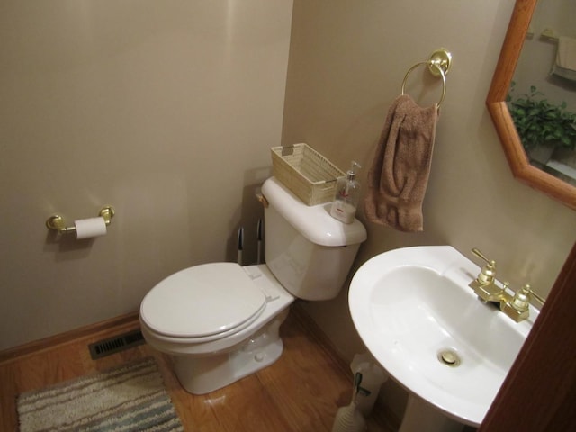 106 Tygert Ln, Dekalb, IL 60115 - bathroom featuring toilet, a sink, wood finished floors, and baseboards