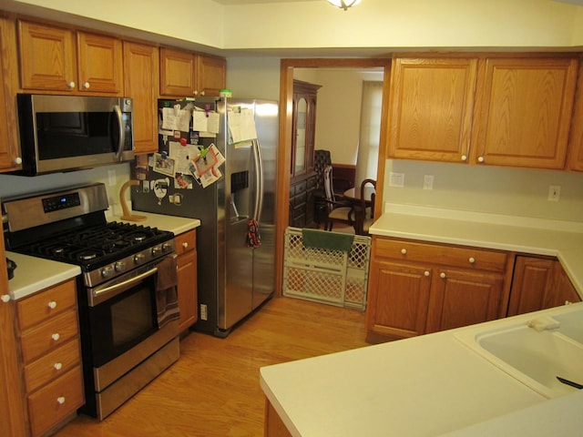 106 Tygert Ln, Dekalb, IL 60115 - kitchen featuring brown cabinets, stainless steel appliances, light wood-type flooring, and light countertops