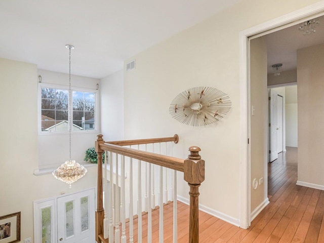 18036 Crystal Ln, Lansing, IL 60438 - corridor featuring an upstairs landing, visible vents, baseboards, light wood-type flooring, and an inviting chandelier