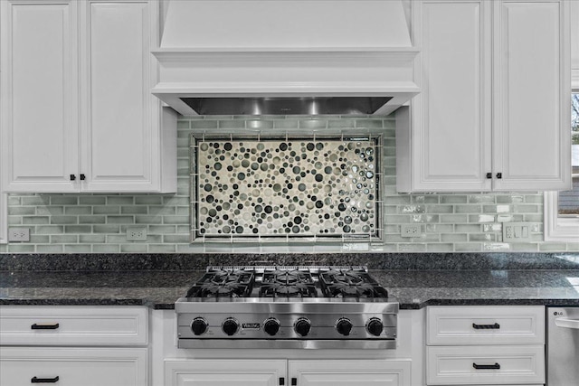 kitchen featuring custom exhaust hood, dark stone counters, appliances with stainless steel finishes, white cabinetry, and backsplash