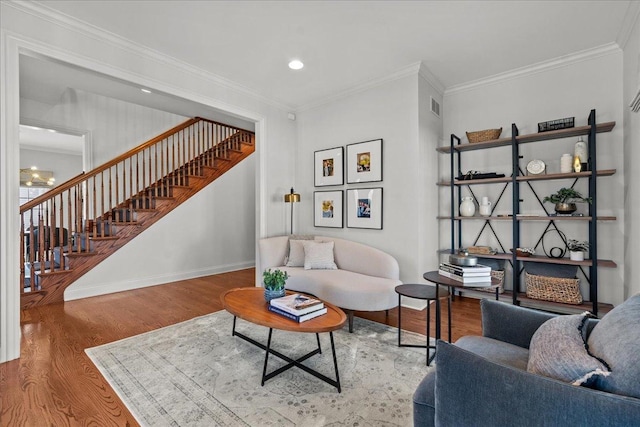 living area with visible vents, baseboards, stairway, ornamental molding, and wood finished floors