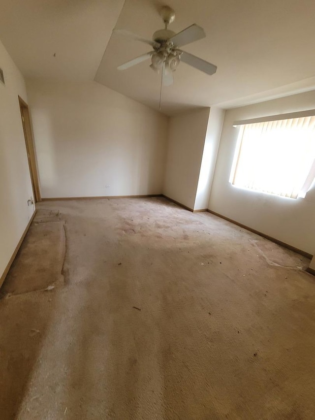 spare room with baseboards, lofted ceiling, ceiling fan, and light carpet