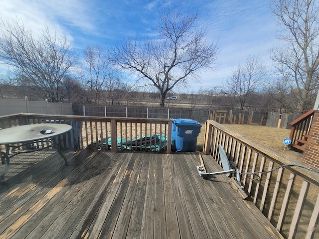 wooden deck with a fenced backyard