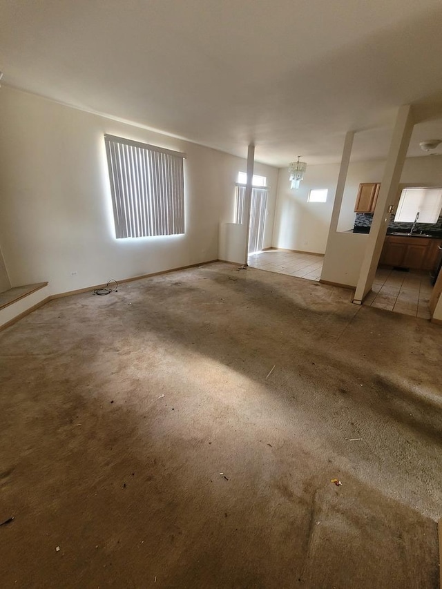 interior space with baseboards, a sink, and light carpet