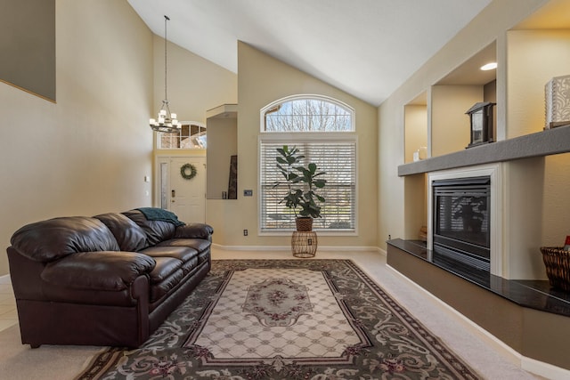 carpeted living area featuring high vaulted ceiling, a notable chandelier, a glass covered fireplace, and baseboards