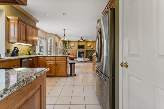 kitchen featuring light tile patterned floors, open floor plan, appliances with stainless steel finishes, a ceiling fan, and a peninsula
