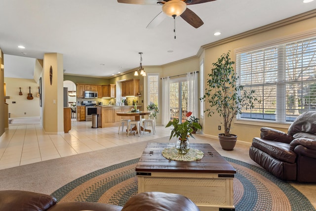 living room with light carpet, light tile patterned floors, baseboards, and a ceiling fan