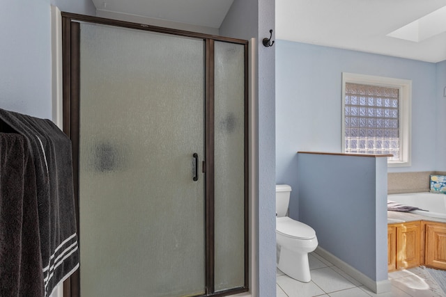 bathroom with toilet, a skylight, a shower stall, tile patterned floors, and a garden tub