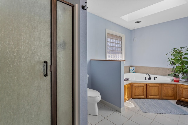 bathroom featuring a garden tub, a shower stall, toilet, a skylight, and tile patterned floors