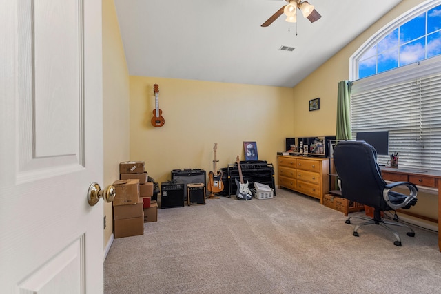 carpeted office featuring visible vents, vaulted ceiling, and ceiling fan