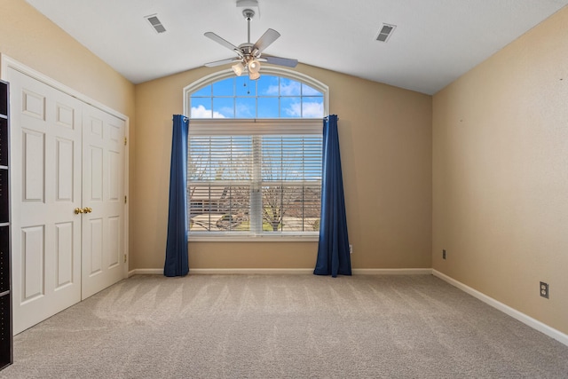 unfurnished bedroom with visible vents, baseboards, carpet flooring, and vaulted ceiling