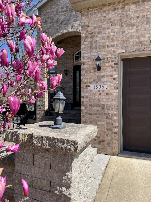 entrance to property featuring brick siding