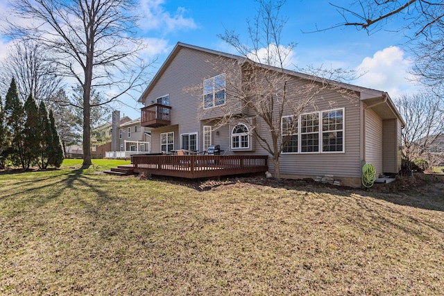rear view of house featuring a yard, a balcony, and a wooden deck