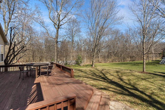 wooden deck featuring outdoor dining space and a lawn