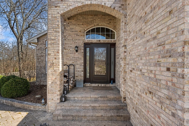 entrance to property featuring brick siding