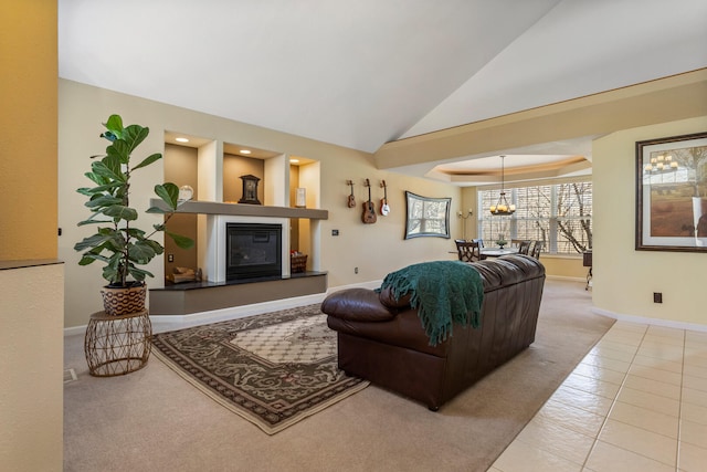 living area with a glass covered fireplace, baseboards, vaulted ceiling, a chandelier, and carpet