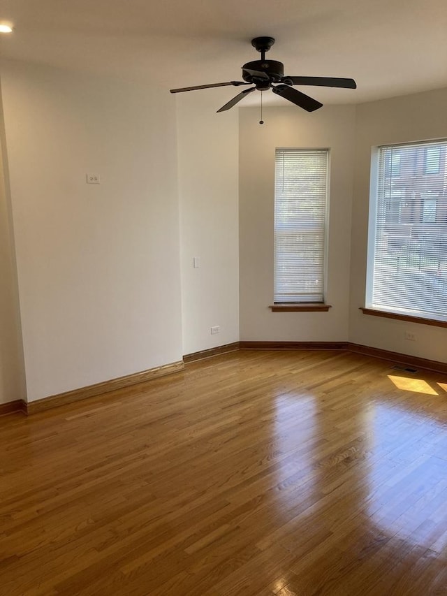 unfurnished room with ceiling fan, baseboards, and wood finished floors