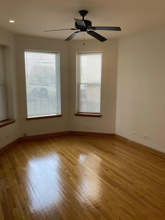 empty room featuring a ceiling fan, wood finished floors, and baseboards