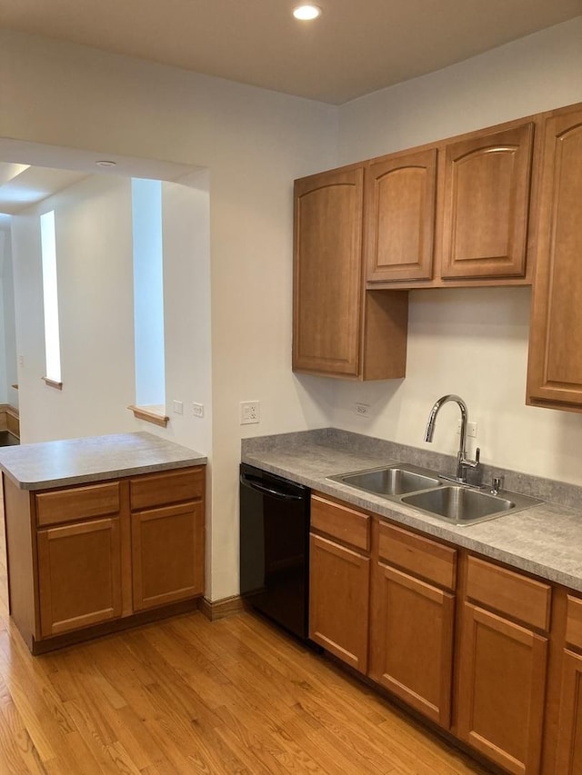 kitchen with light wood-type flooring, a sink, a peninsula, brown cabinetry, and dishwasher