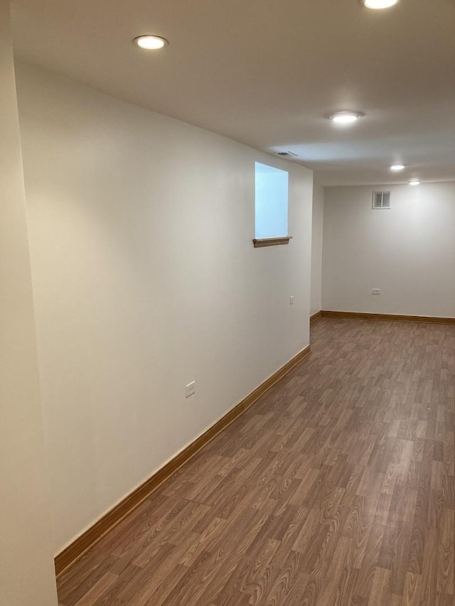 basement featuring recessed lighting, visible vents, baseboards, and dark wood-type flooring