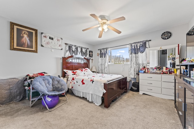 bedroom featuring light carpet and a ceiling fan