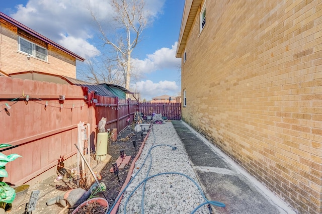 view of side of home with brick siding and a fenced backyard