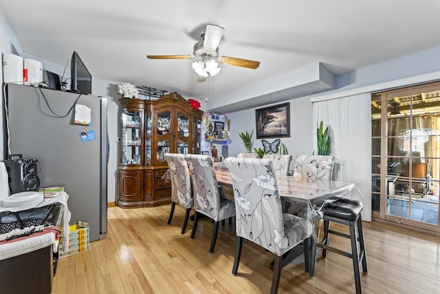 dining space with light wood finished floors and ceiling fan