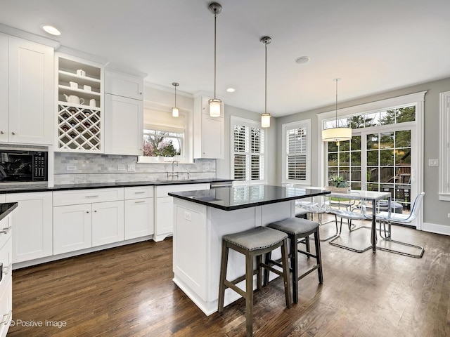 513 W Chicago Ave, Hinsdale, IL 60521 - kitchen featuring built in microwave, decorative backsplash, a sink, a breakfast bar, and white cabinets