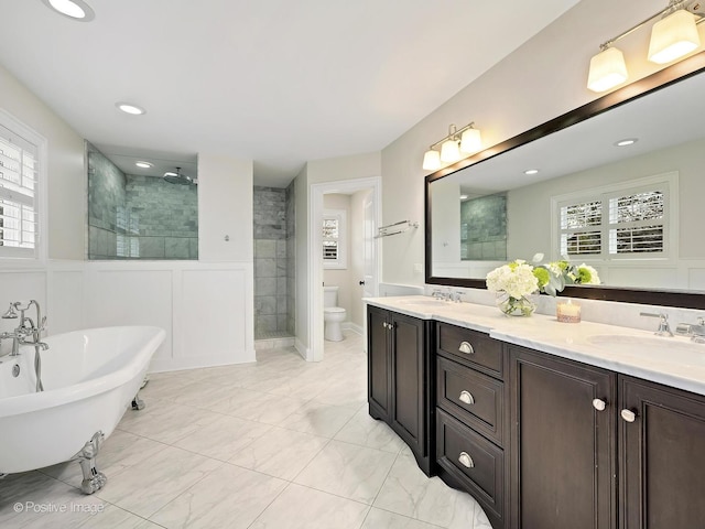 513 W Chicago Ave, Hinsdale, IL 60521 - bathroom featuring walk in shower, double vanity, marble look tiles, a freestanding tub, and toilet