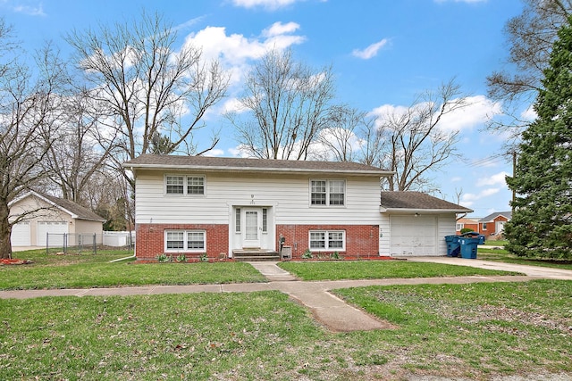 bi-level home with driveway, a front yard, fence, an attached garage, and brick siding
