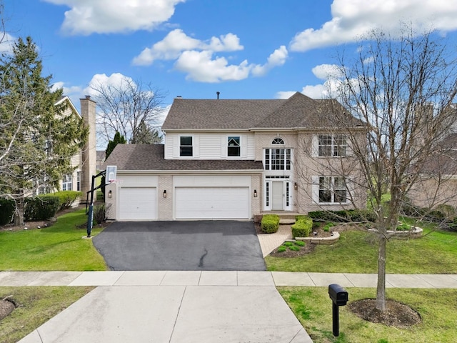 traditional home with aphalt driveway, a front yard, an attached garage, and roof with shingles