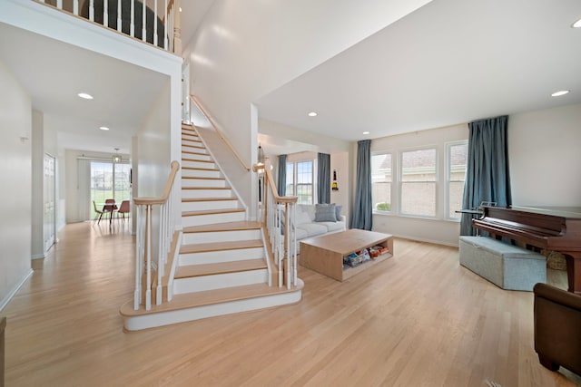 staircase with baseboards, wood finished floors, and plenty of natural light