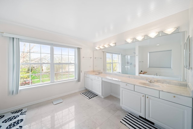 bathroom with baseboards, a stall shower, double vanity, and a sink