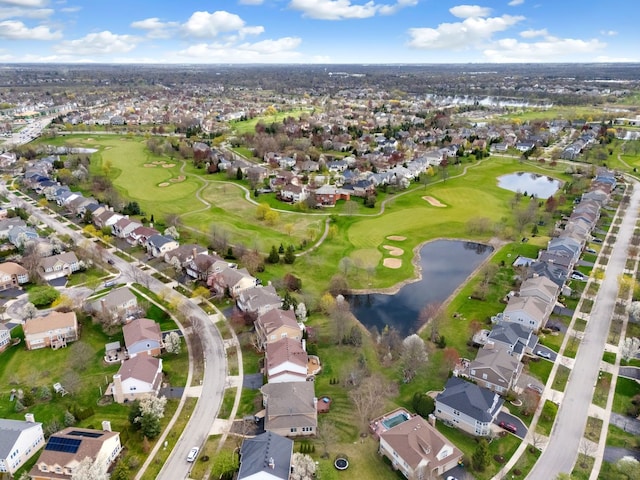 drone / aerial view featuring golf course view, a residential view, and a water view