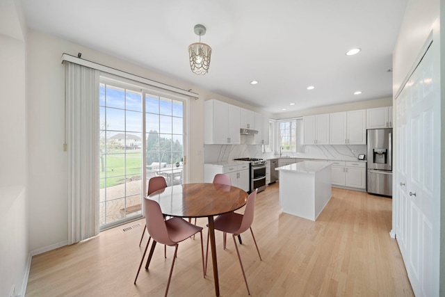 dining space featuring baseboards, light wood-type flooring, visible vents, and recessed lighting
